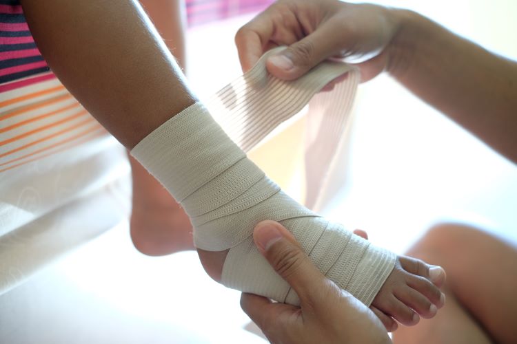 Ankle being bandaged / Rhwymo pigwrn