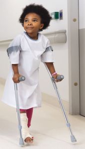Child walking with crutches and broken lower leg / Plentyn yn cerdded gyda baglau a rhan isaf y goes wedi’i thorri