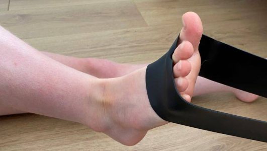 Rhowch eich troed mewn band gwrthiant latecs neu dywel wedi’i rolio’n dynn.